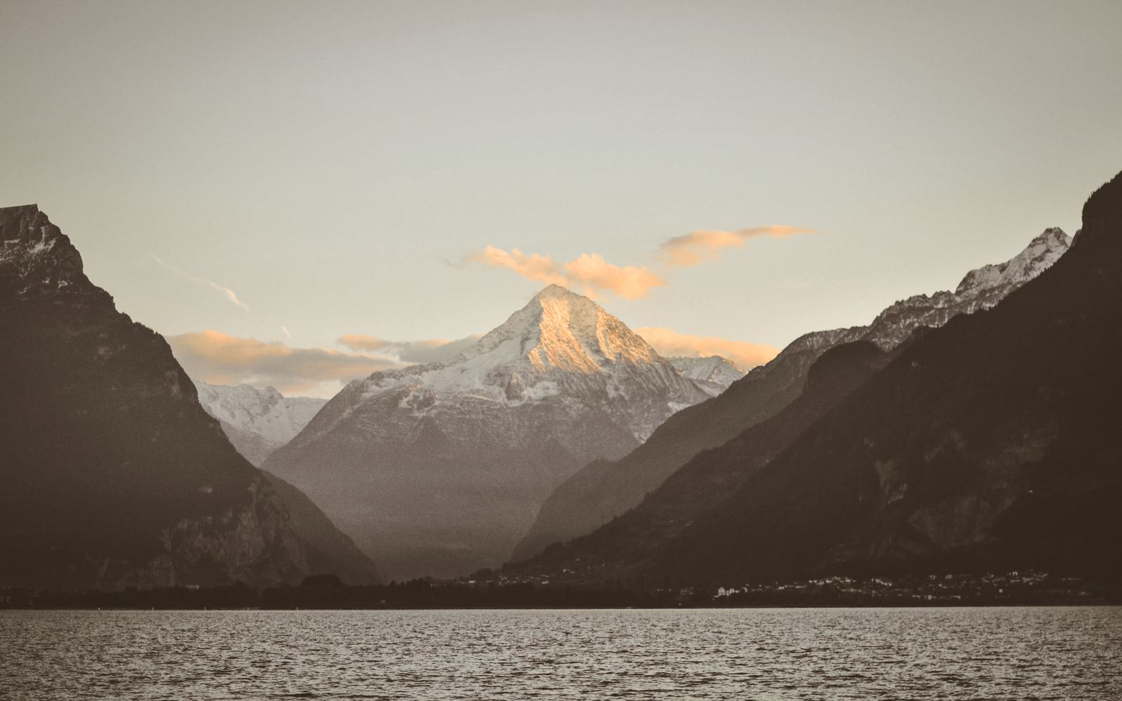 Snow-capped Alps above a lake at first light